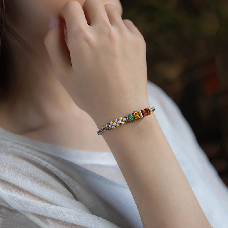Armband Pfirsichblüte mit bunten Perlen am Handgelenk getragen elegant