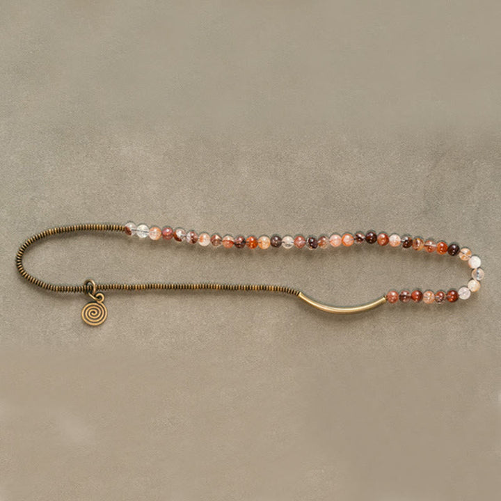 Armband Kupfer – Liebe mit Perlen und Spiralanhänger auf beige Hintergrund.