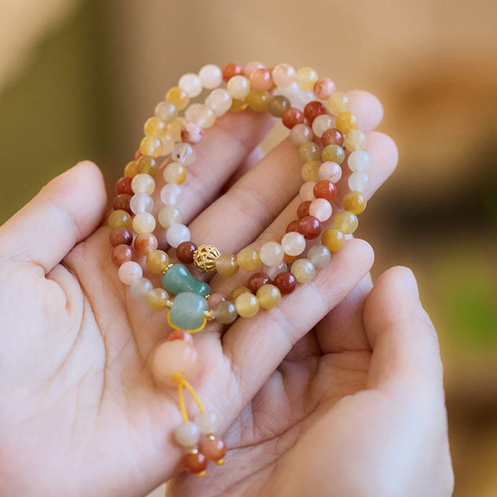 Jade Armband Gold mit mehrfarbigen Natursteinen am Handgelenk getragen elegant