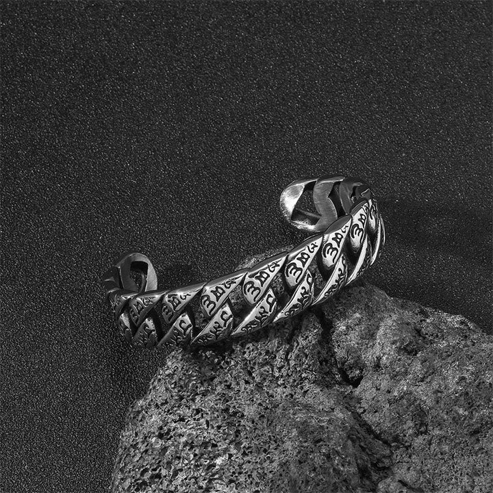 Silbernes Om Mani Padme Hum Armband auf Stein, schwarzweiß Fotografie.