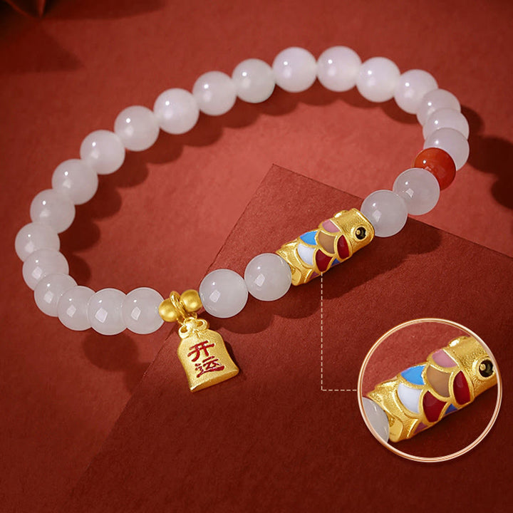 Weiße Jade Armband mit goldenem Koi Fisch Anhänger elegant präsentiert
