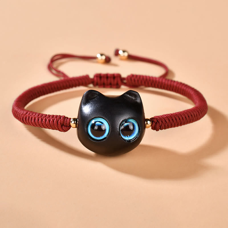 Armband Ebenholz Katze mit blauen Augen, rotes Textilband elastisch.