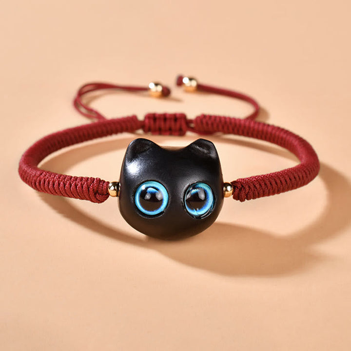 Armband Ebenholz Katze mit blauen Augen, rotes Textilband elastisch.