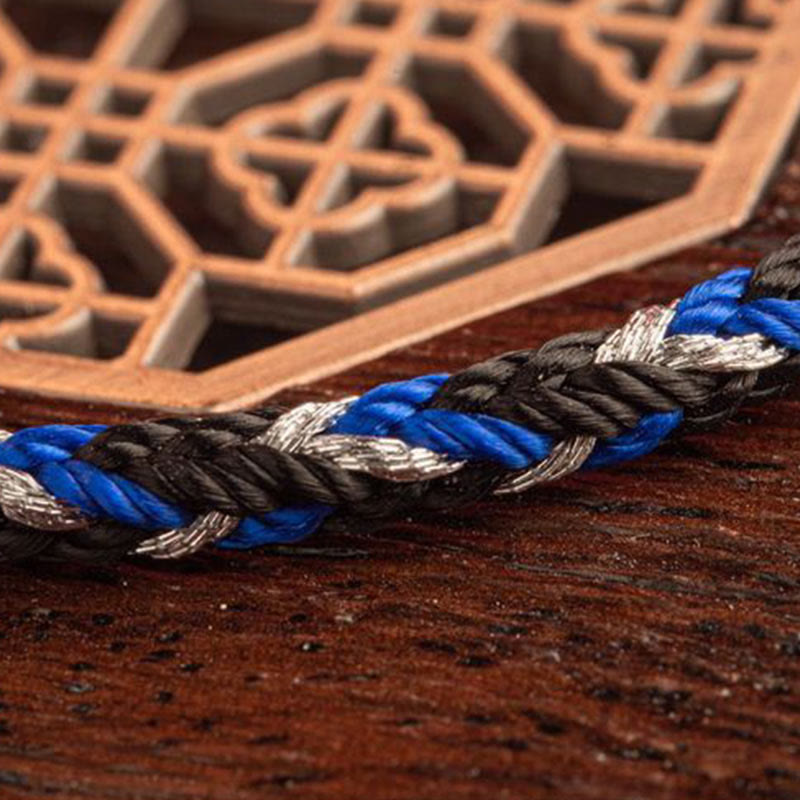 Mehrfarbiges Glücksband Armband blau schwarz weiß geflochten Nahaufnahme