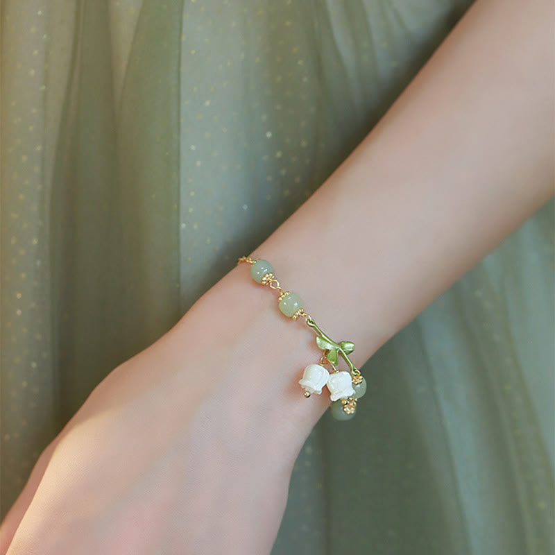 Armband Grüne Jade – Wohlstand mit weißen Blütenanhängern elegant getragen