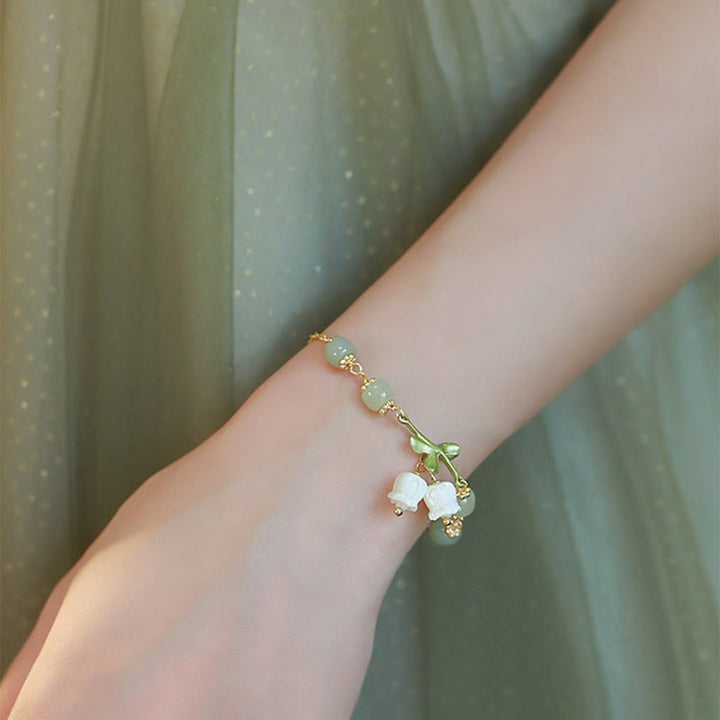 Armband Grüne Jade – Wohlstand mit weißen Blütenanhängern elegant getragen