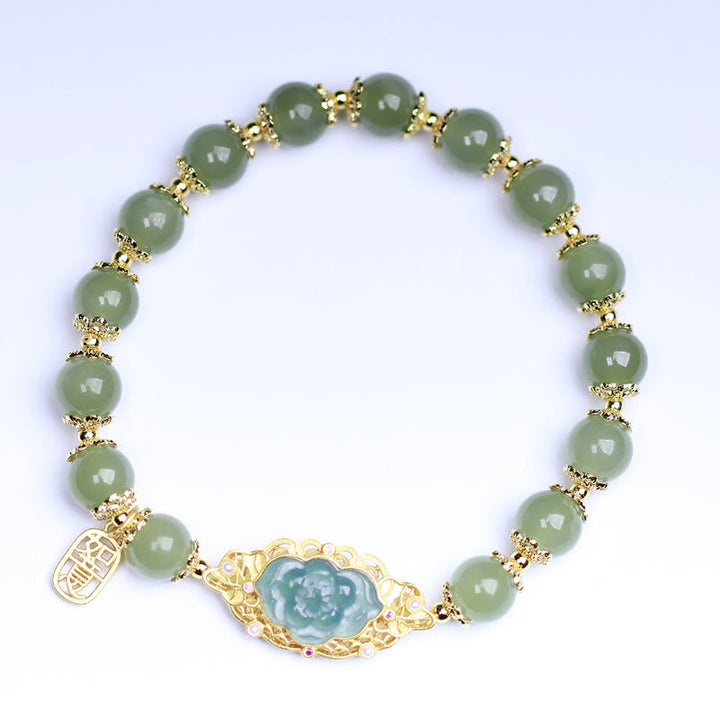 Grünes Jade Armband mit Lotus-Anhänger goldfarbig elegant gestylt.