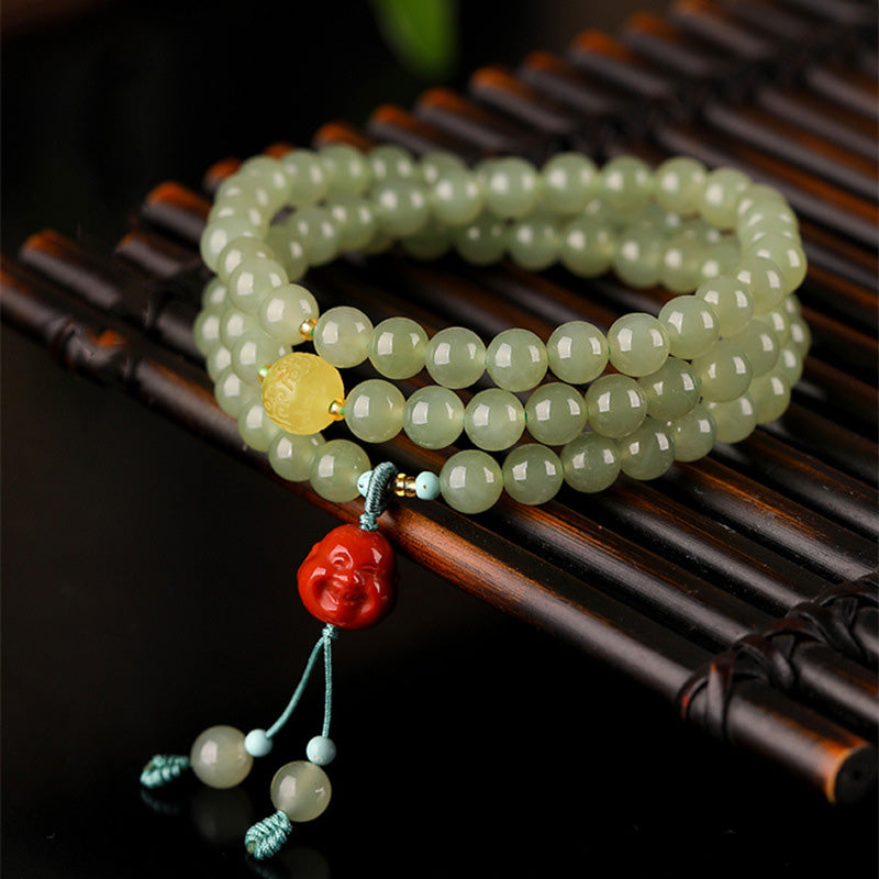 Jade Armband mit rotem Achat Buddha Perlen auf Holz Untergrund.