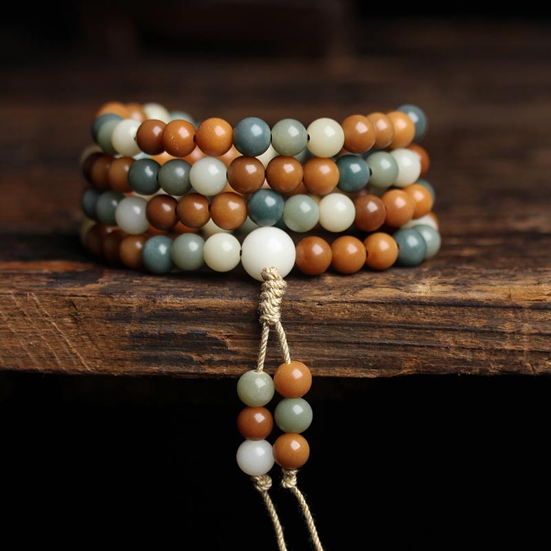 Mala Bodhi Harmonie Armband aus braunen grünen und weißen Natursteinen Holzuntergrund