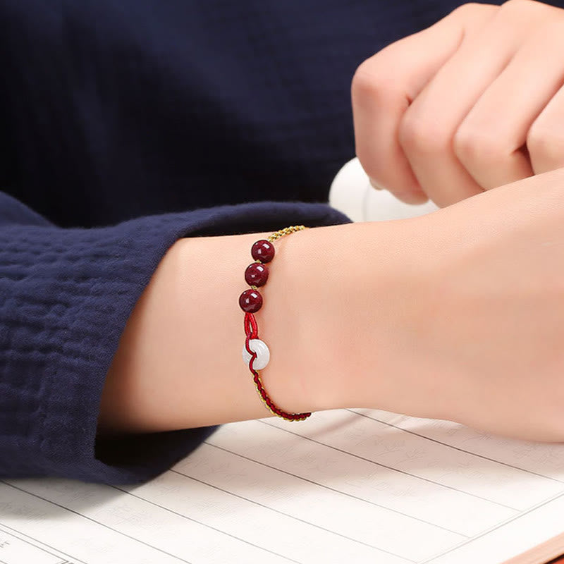 Armband Zinnober Jade – Frieden & Segen mit weißem Herz elastisch getragen