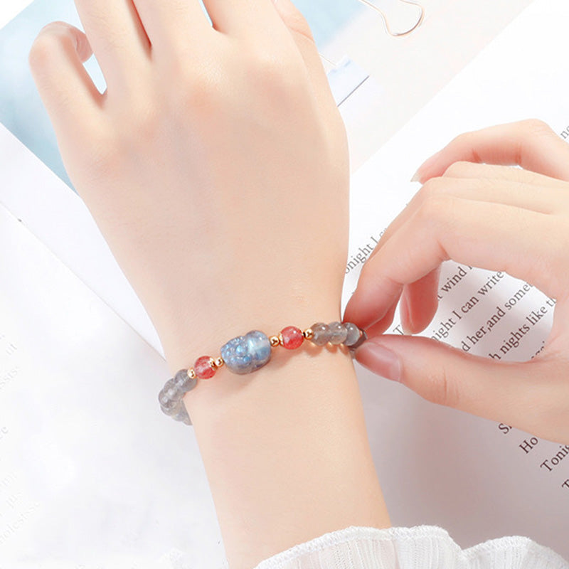 Armband Erdbeerquarz Mondstein Pixiu am Handgelenk getragen Heilstein