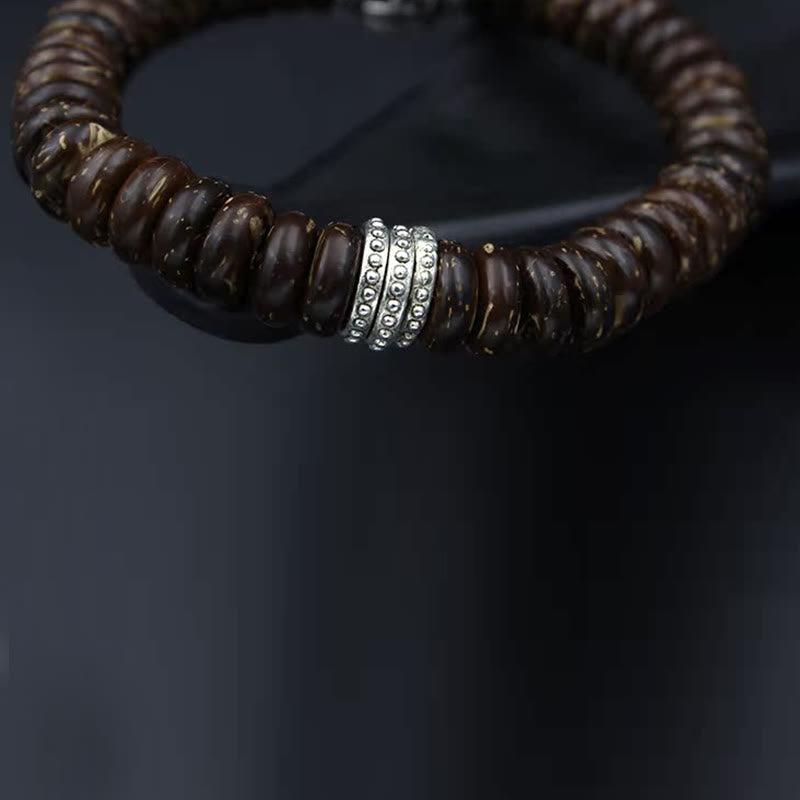 Braunes Perlen Armband mit silbernen Verzierungen am Handgelenk getragen Energie