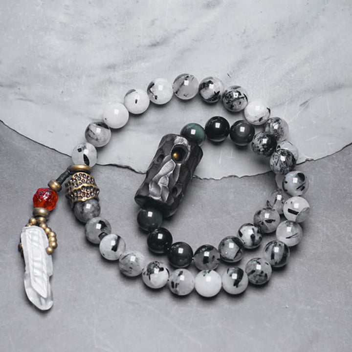 Armband mit weißem Kristall und Ebenholz auf Marmor arrangiert.