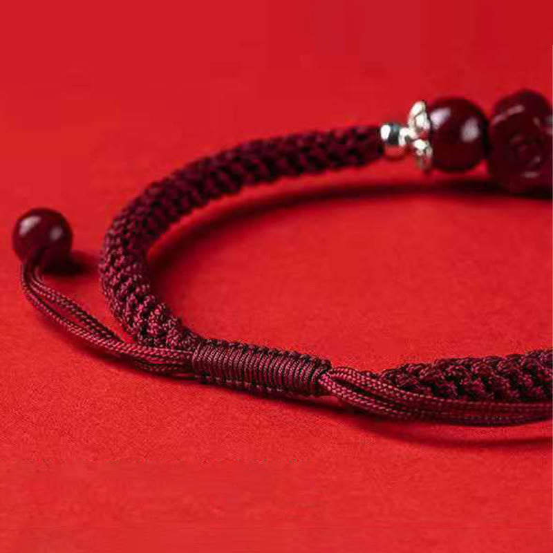 Rotes Armband Zinnober Pixiu mit Perlen auf rotem Hintergrund Nahaufnahme