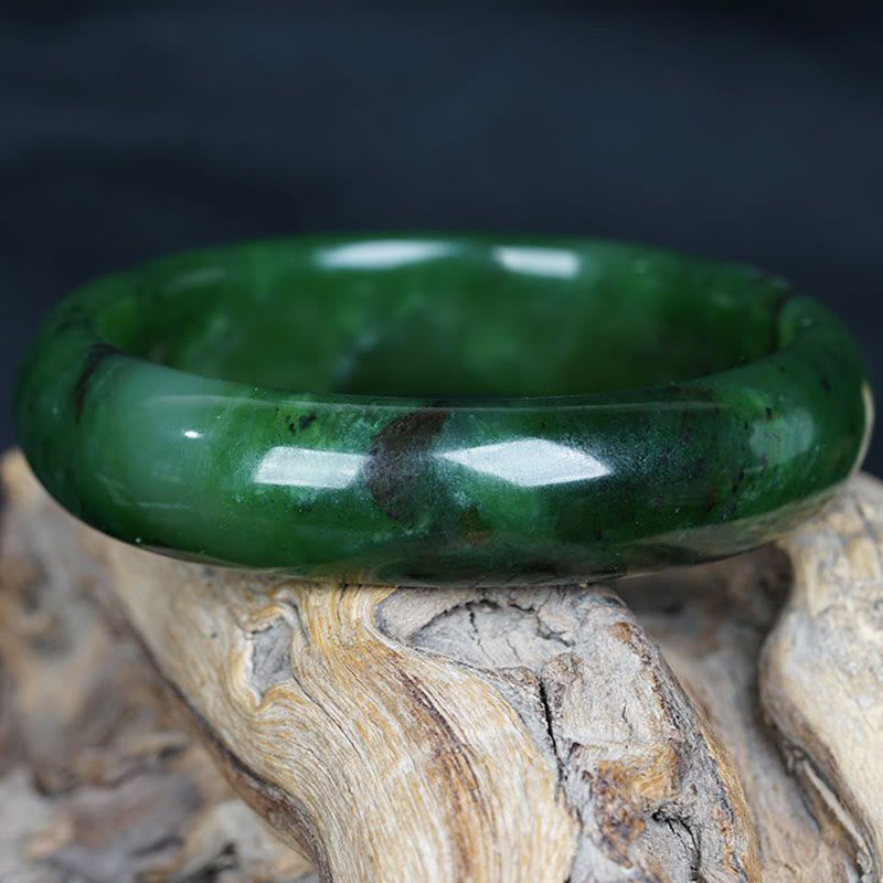 Grünes Jade Armband auf Holz, poliert glänzend, Glück Erfolg
