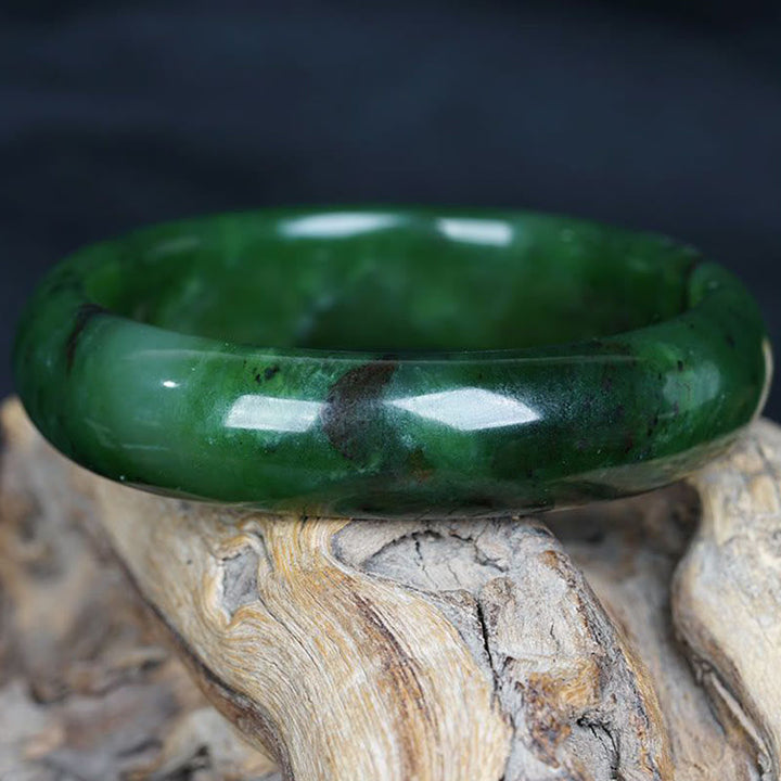 Grünes Jade Armband auf Holz, poliert glänzend, Glück Erfolg