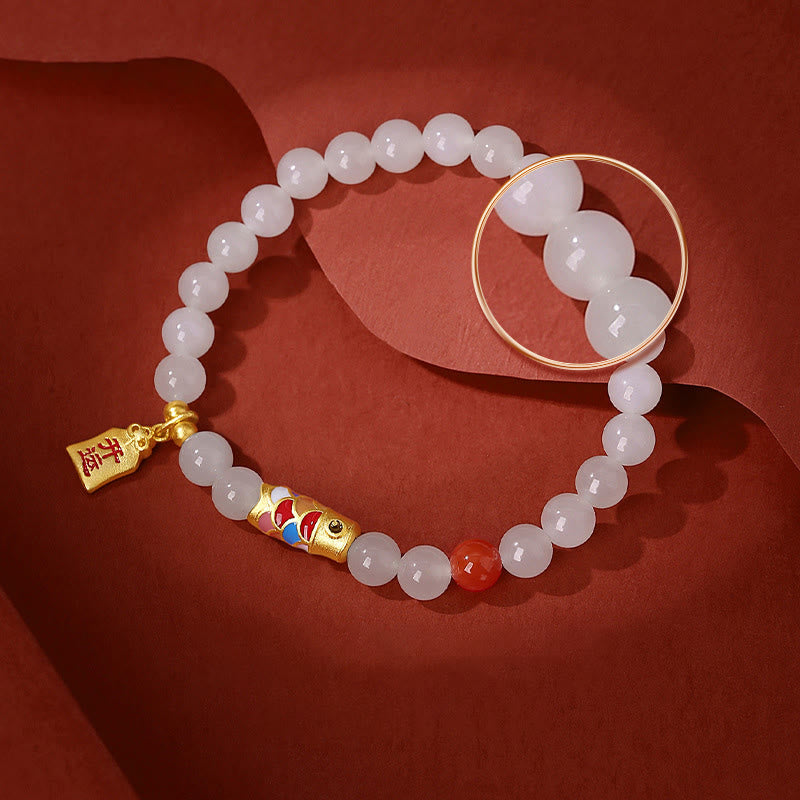 Weißes Jade Armband mit goldenem Koi Fisch Charm elegant getragen
