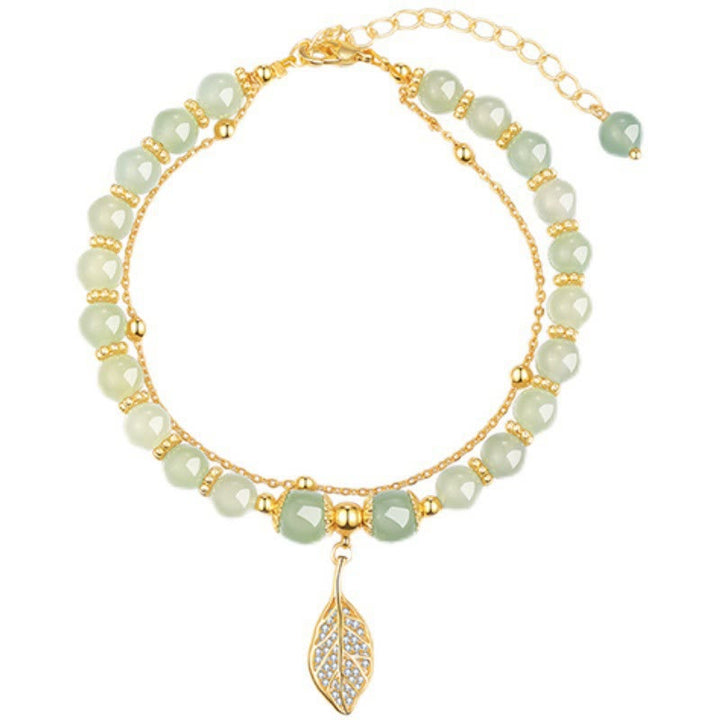 Jade Armband mit goldenem Blattanhänger und Perlen.