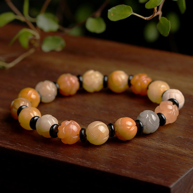 Jade Lotus Armband mit mehrfarbigen Steinen und schwarzen Perlen Holzuntergrund