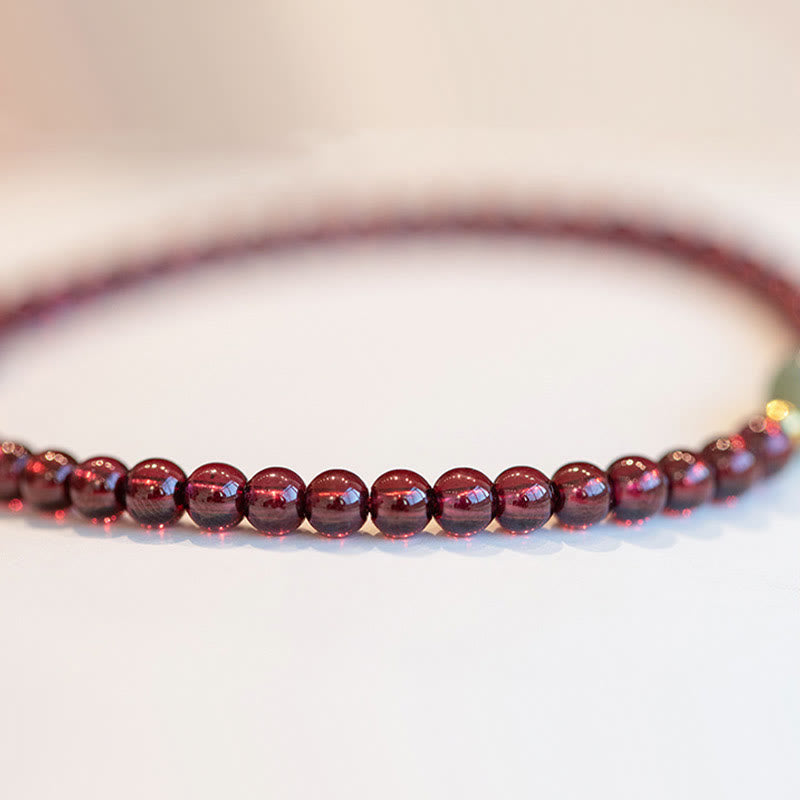 Armband Erdbeerquarz Granat Fu-Zeichen rote glänzende Perlen elastisch