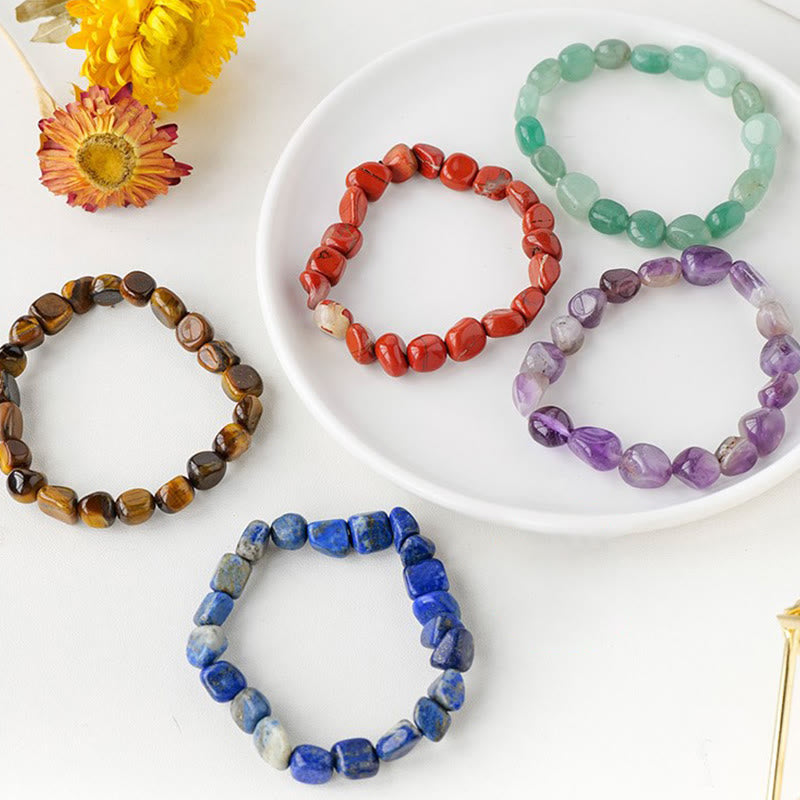 Bunte Kristall Armbänder mit Edelsteinen auf weißem Teller.