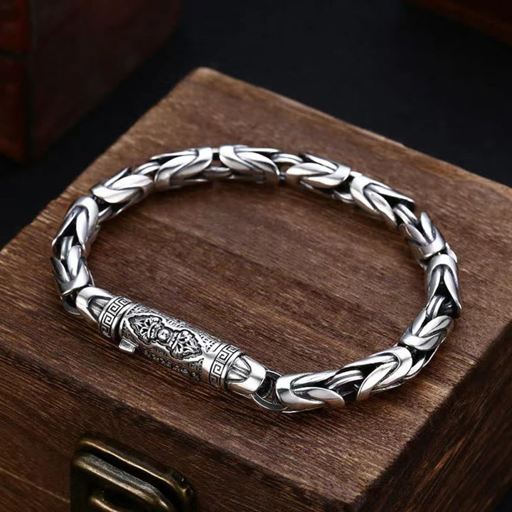 Silbernes Armband mit Om Mani Padme Hum Gravur auf Holzbox.