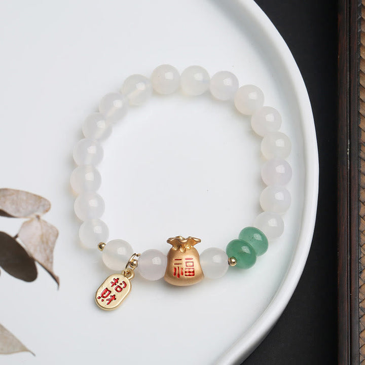 Weißes Jade Armband mit grünem Achat und goldenen Anhängern elegant.