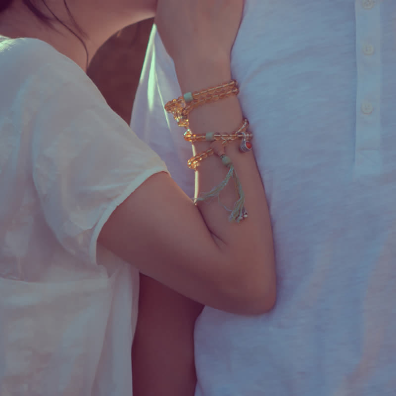 Mala Armband aus Sandelholz mit goldenen Perlen am Handgelenk getragen elegant