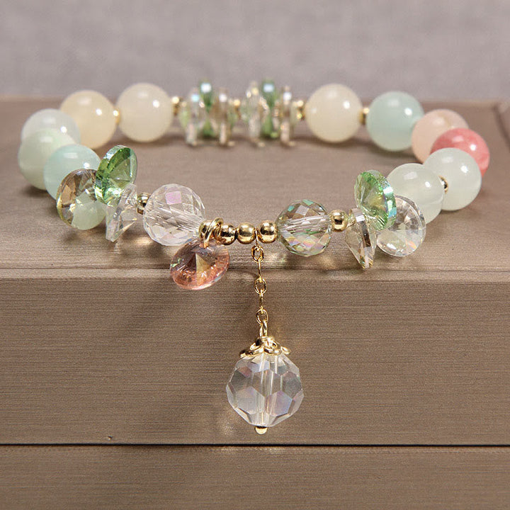 Elegantes Kristall-Armband mit Perlen und Anhänger auf Holz.