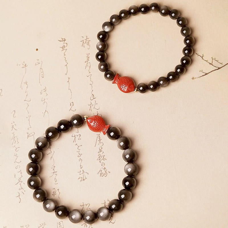 Obsidian Armband mit rotem Koi Fisch Anhänger auf Papier