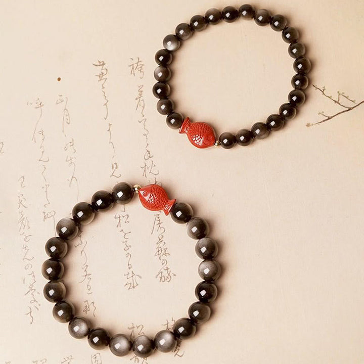 Obsidian Armband mit rotem Koi Fisch Anhänger auf Papier