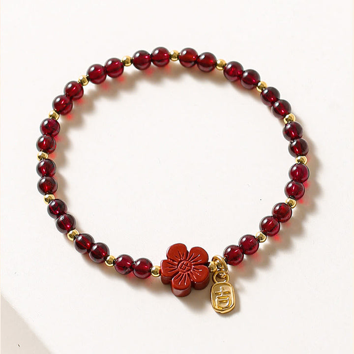Rotes Granat Armband mit Blütenanhänger und 14k Goldperlen Nahaufnahme