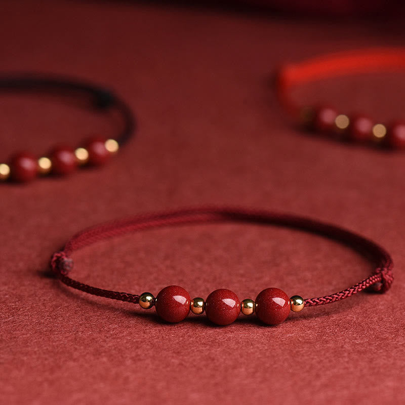 Zinnober Armband mit roten Perlen auf rotem Hintergrund, Glück & Segen Schmuck
