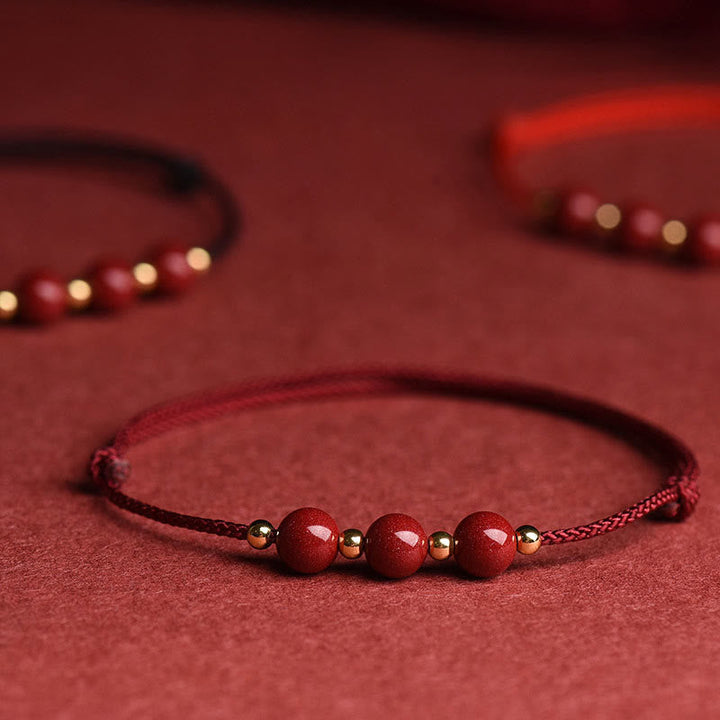 Zinnober Armband mit roten Perlen auf rotem Hintergrund, Glück & Segen Schmuck