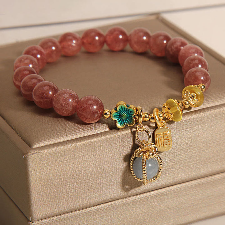 Armband Erdbeerquarz Aquamarin mit goldenen Elementen und Blumenverzierung.