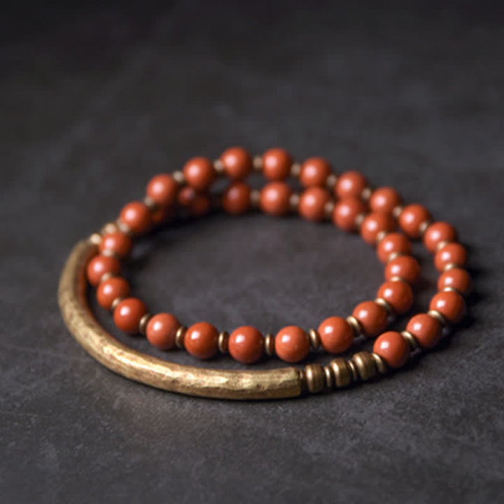 Rotes Perlen Armband mit Metallverzierung auf dunklem Hintergrund Nahaufnahme