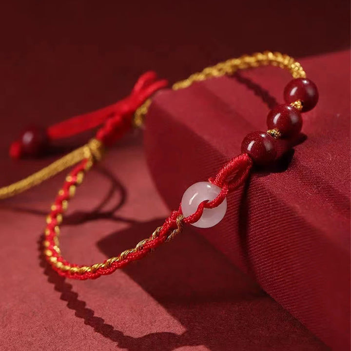 Armband Zinnober Jade mit roten Perlen und goldener Schnur elegant.