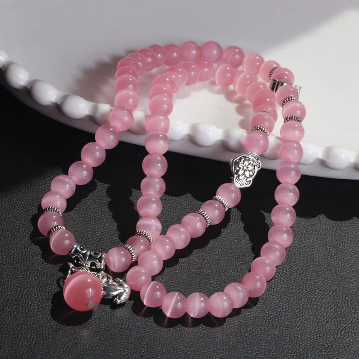 Rosafarbenes Katzenauge Armband PiXiu mit silbernen Perlen elastisch.