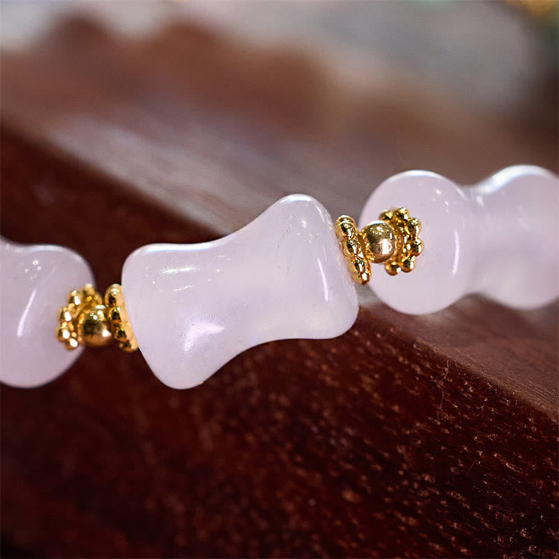 Jade Fu-Zeichen Armband mit goldenen Perlen auf Holzoberfläche elegant.