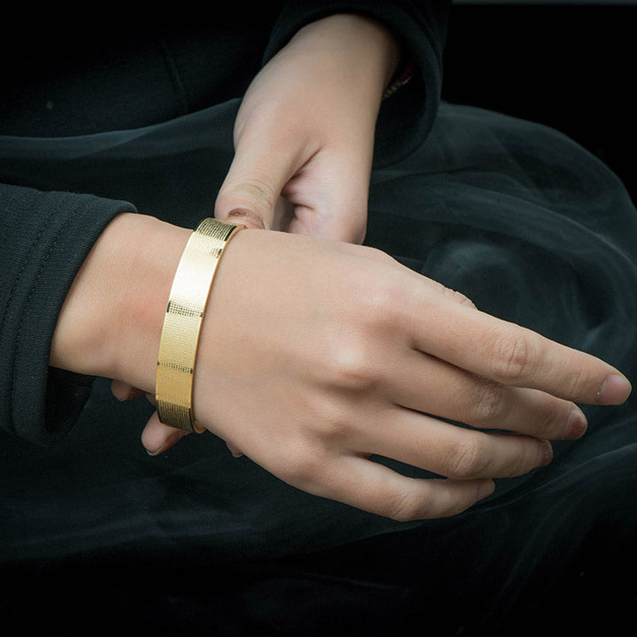 Goldenes Armband Shurangama Mantra Gravierung Titanstahl am Handgelenk getragen.