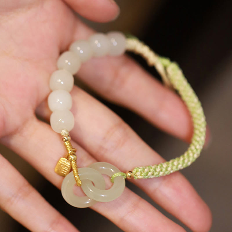 Jade Fu-Zeichen Armband mit grünem Seil elastisch am Handgelenk getragen.