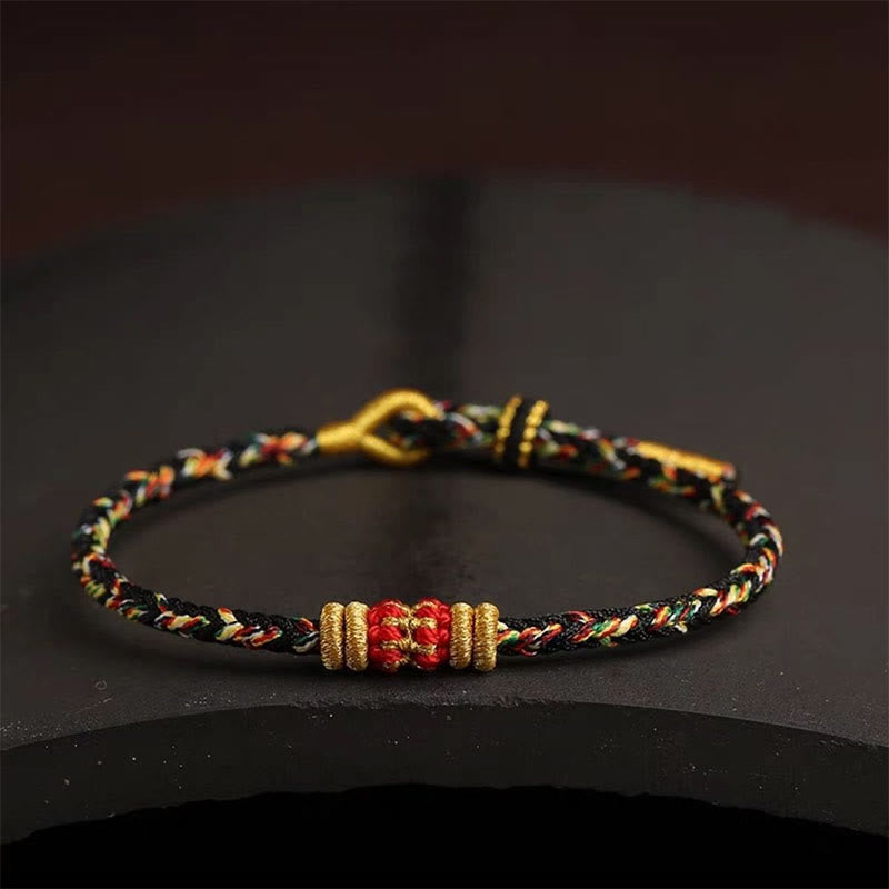 Armband bunt geflochten Knoten Glück goldene Perlen schwarzer Hintergrund