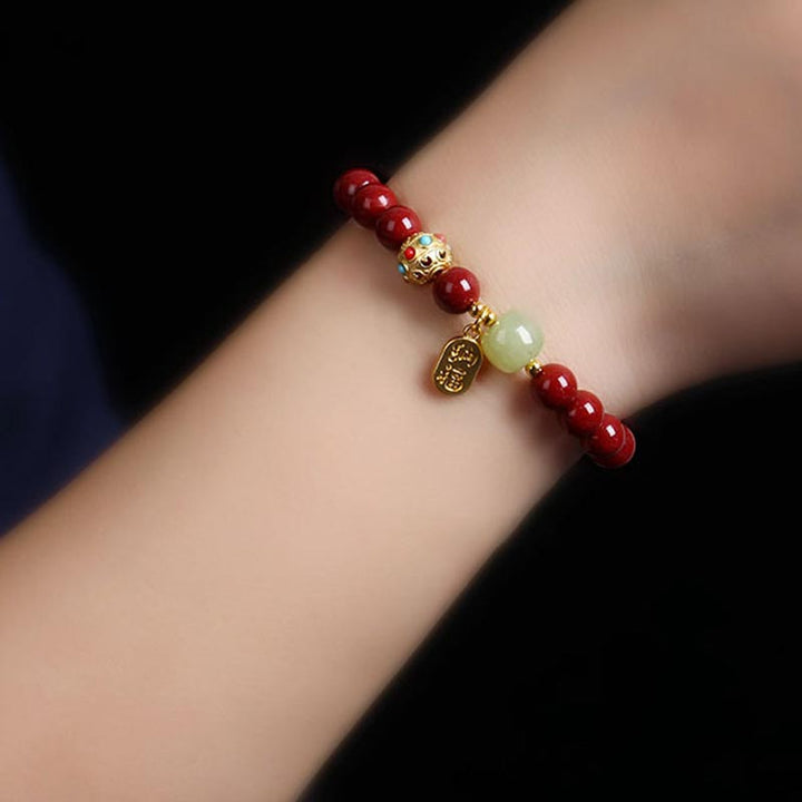 Armband Grüner Aventurin Zinnober am Handgelenk getragen rote Perlen goldene Verzierungen