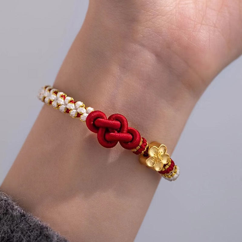 Rotes Armband Pfirsichblüte – Glück & Liebe mit goldenen Perlen am Handgelenk.
