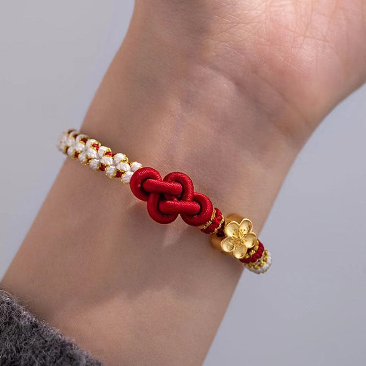 Rotes Armband Pfirsichblüte – Glück & Liebe mit goldenen Perlen am Handgelenk.