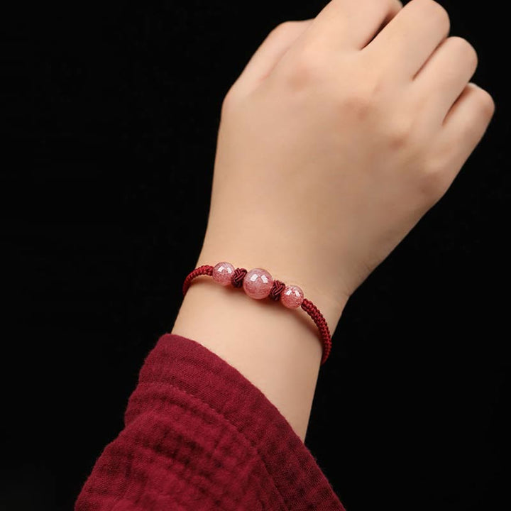 Armband Erdbeerquarz Kristall – Liebe am Handgelenk mit roten Perlen getragen