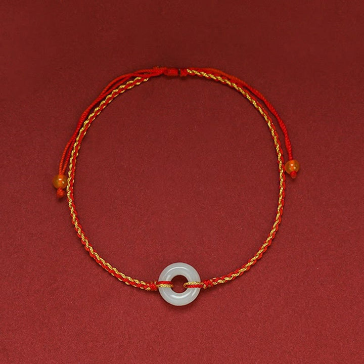 Rotes Armband Jade mit goldenem Faden und weißem Stein Anhänger.
