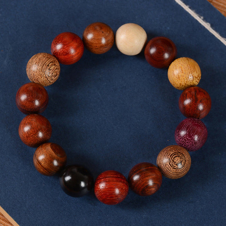 Armband Sandelholz – Schutz & Heilung mit bunten Holzperlen auf blauem Hintergrund.
