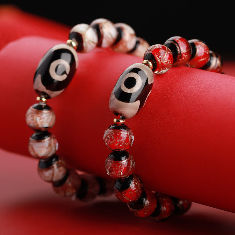 Armband – Wohlstand Balance mit roten Perlen und schwarzen Elementen elegant.
