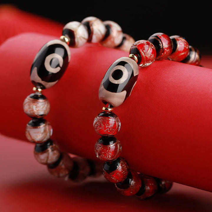 Armband – Wohlstand Balance mit roten Perlen und schwarzen Elementen elegant.